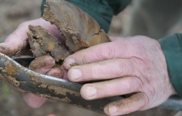 Des mains retirent la terre d’une tarière, après prélèvement pour analyse du RSH 2023